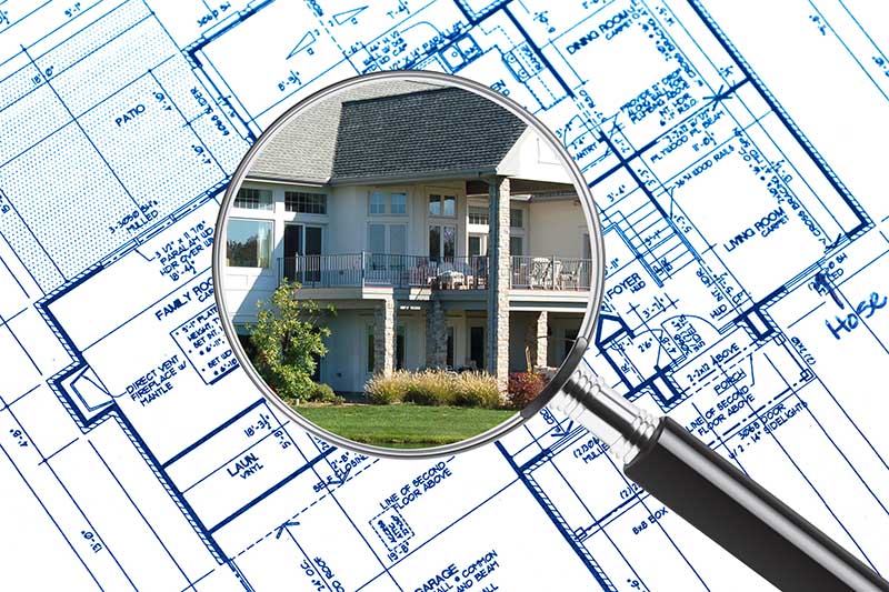 Home Inspection Services magnifying glass over a house and blueprints 